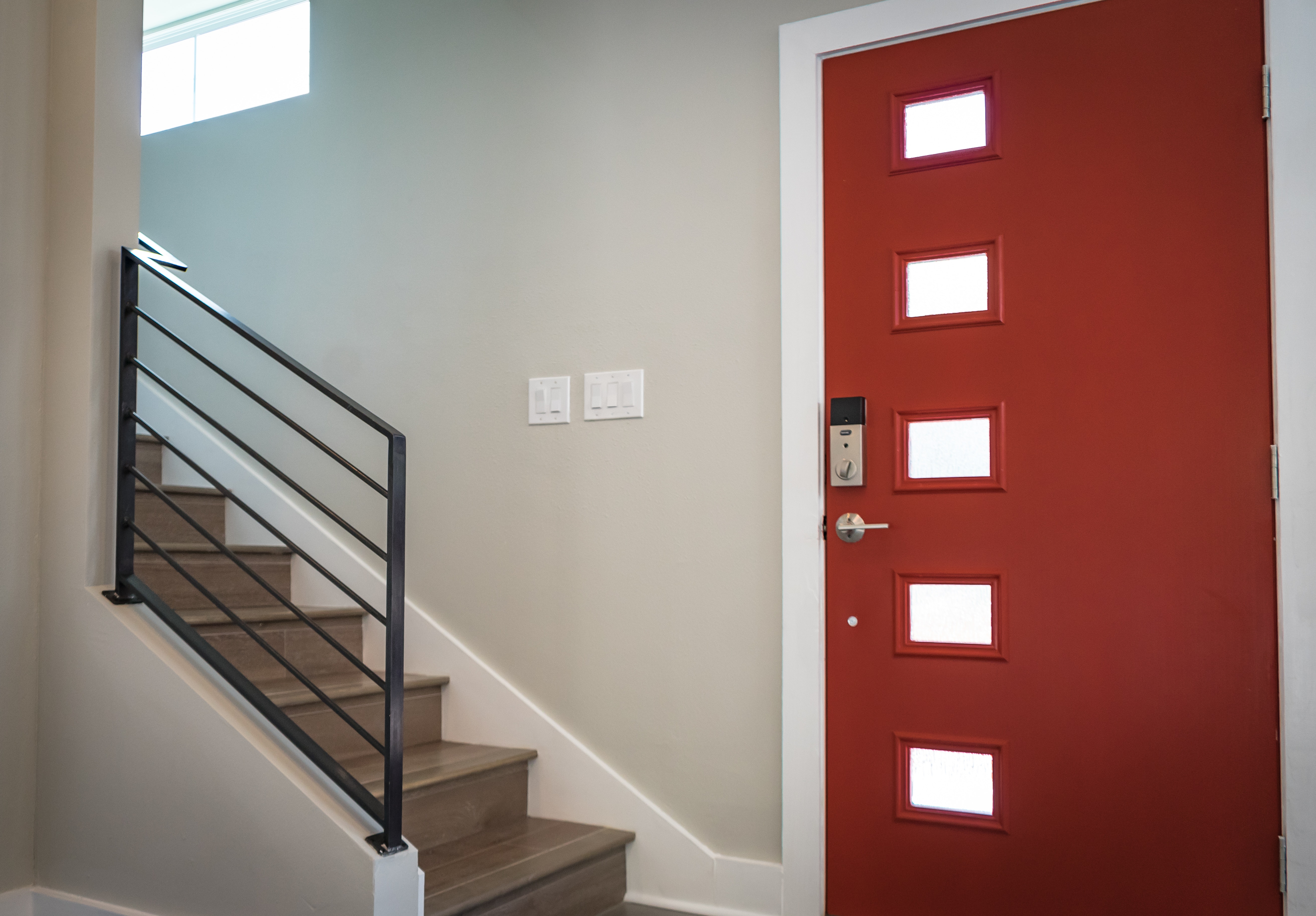 L'entrée d'une maison avec la porte peinte en rouge